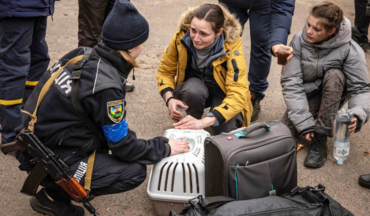 A woman reacts as she is assisted by police